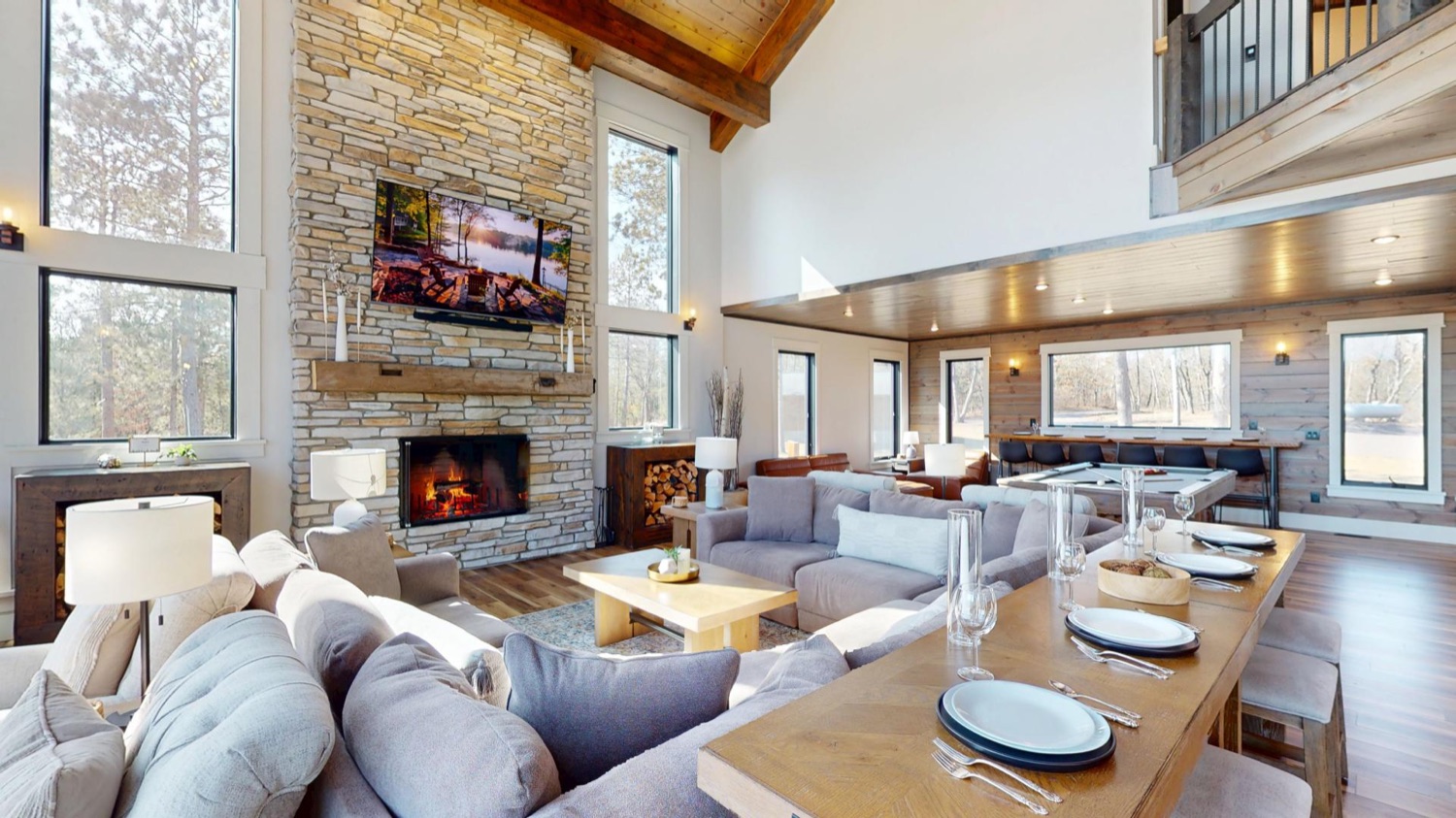 The Great Room's floor-to-ceiling stone fireplace and vaulted wood-beam ceiling